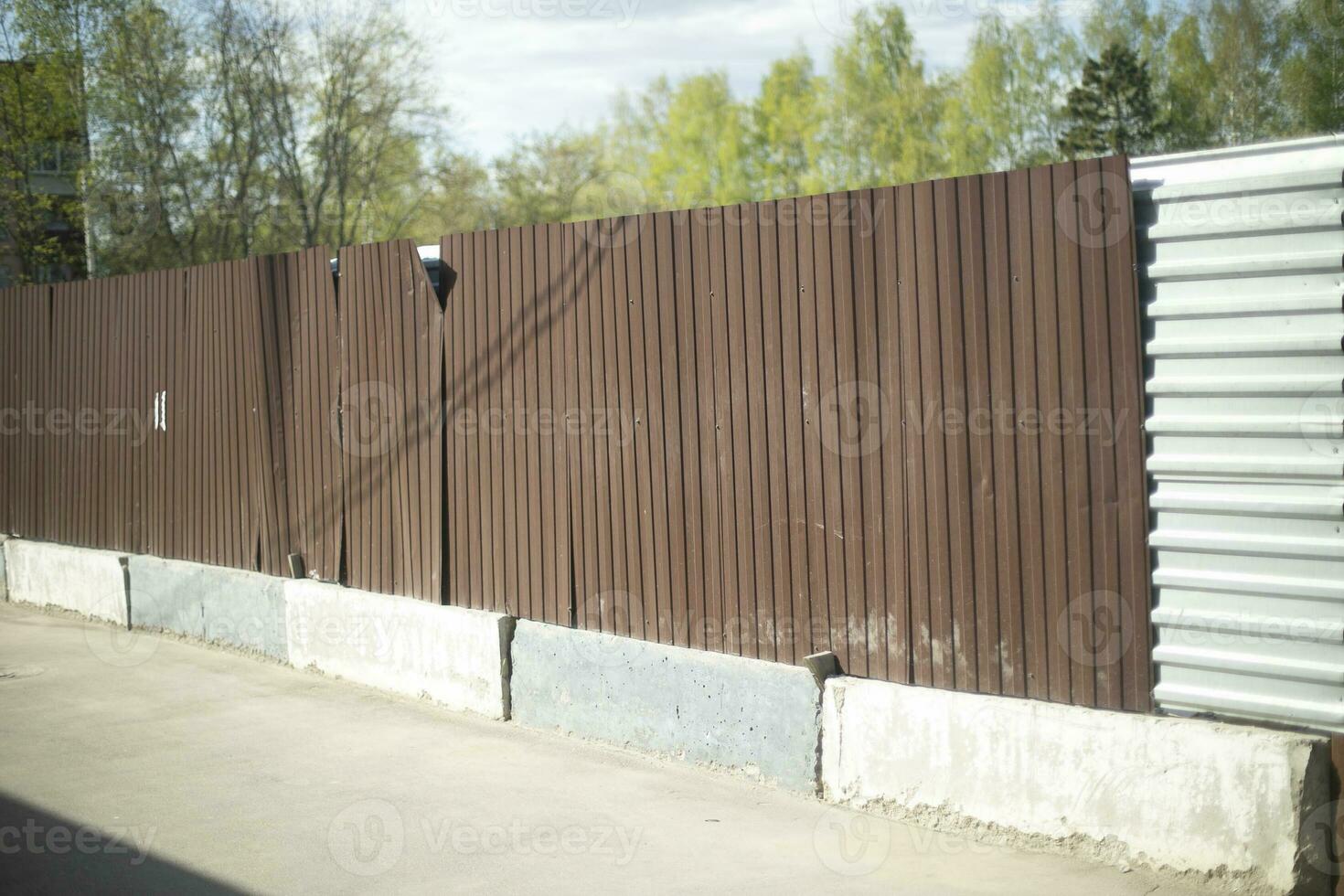 Steel fence. Abandoned construction site. Brown fence. photo