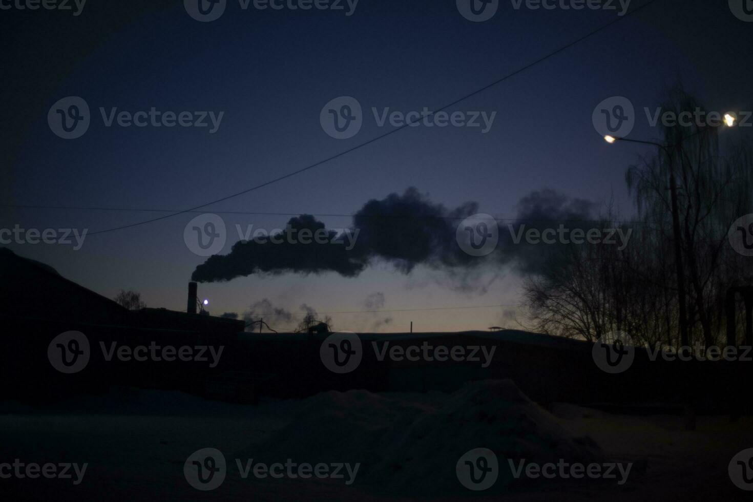 Smoke from chimney at sunset. Evening landscape with factory. Smoke in sky. photo