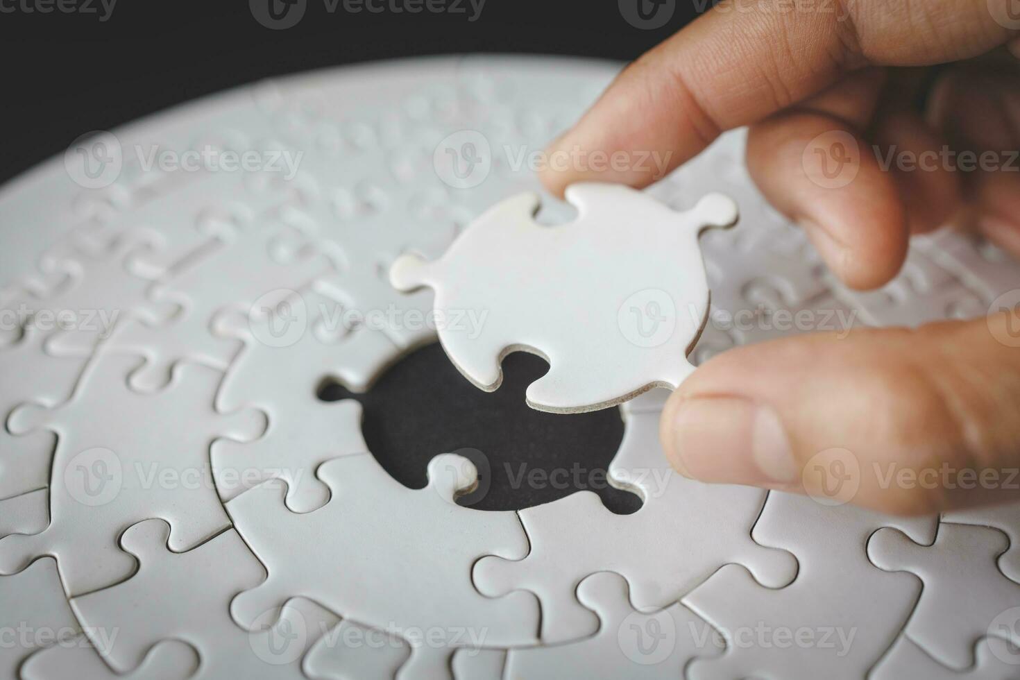 Hand put the last piece of jigsaw puzzle to complete the mission. Completing final task, missing jigsaw puzzle pieces and business concept with a puzzle piece missing. photo