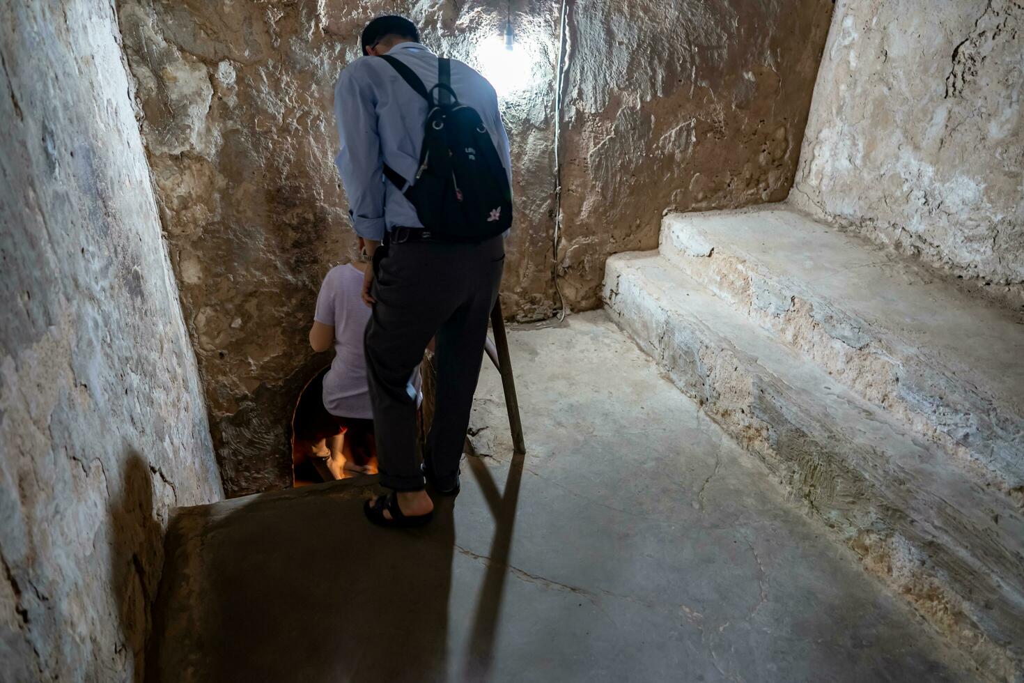 The Cu Chi tunnels. A guide demonstrating how a Vietcong hide into the Tunnel. It's used in Vietnam war. Famous tourist attraction in Vietnam. Stock photo