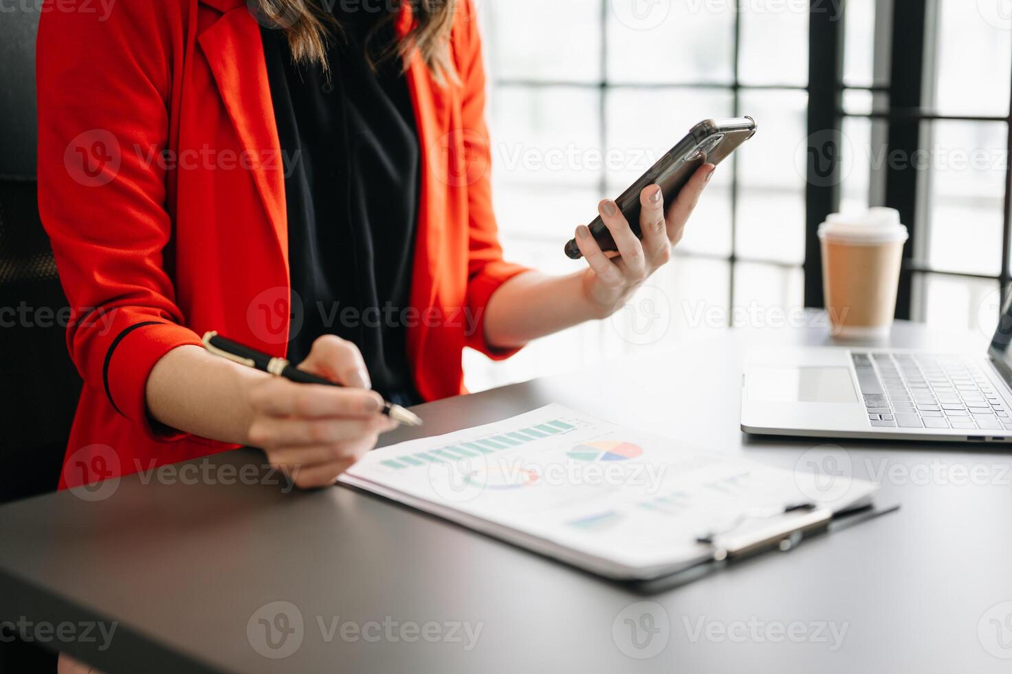 business documents on office table with smart phone and digital tablet and graph financial and woman working at office photo
