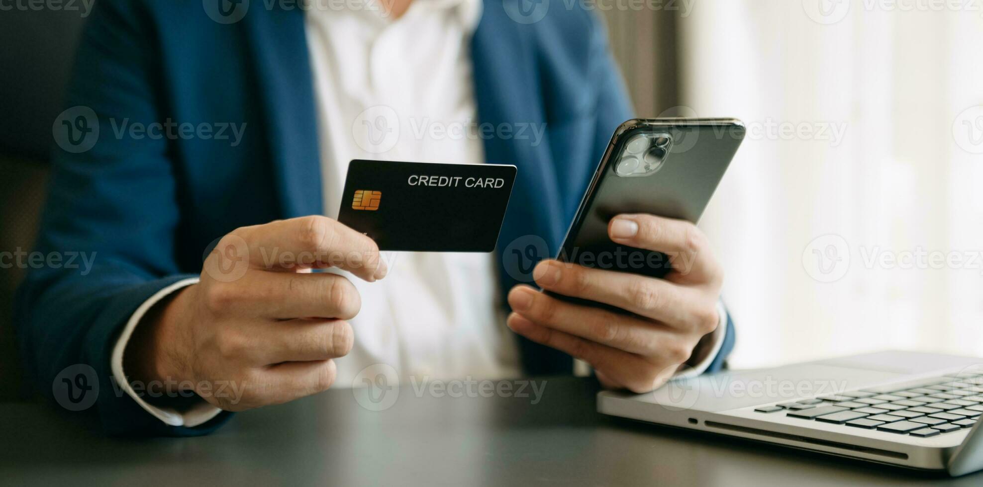 Man using smart phone for mobile payments online shopping,omni channel,sitting on table,virtual icons graphics interface screen photo