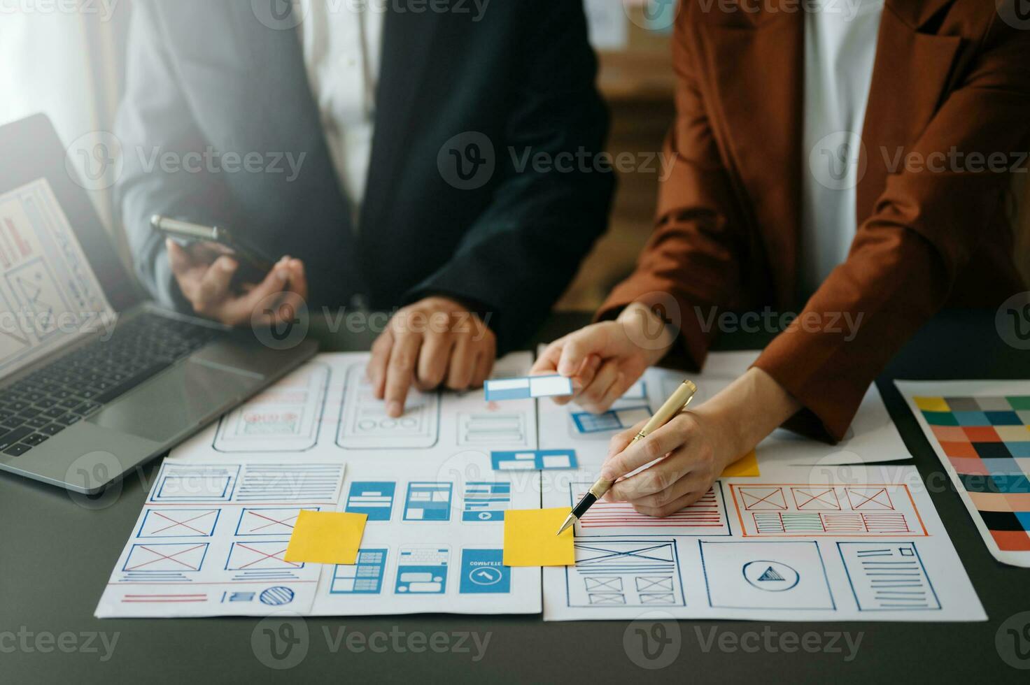 UX developer and ui designer brainstorming about mobile app interface wireframe design with customer breif and color code at office. photo