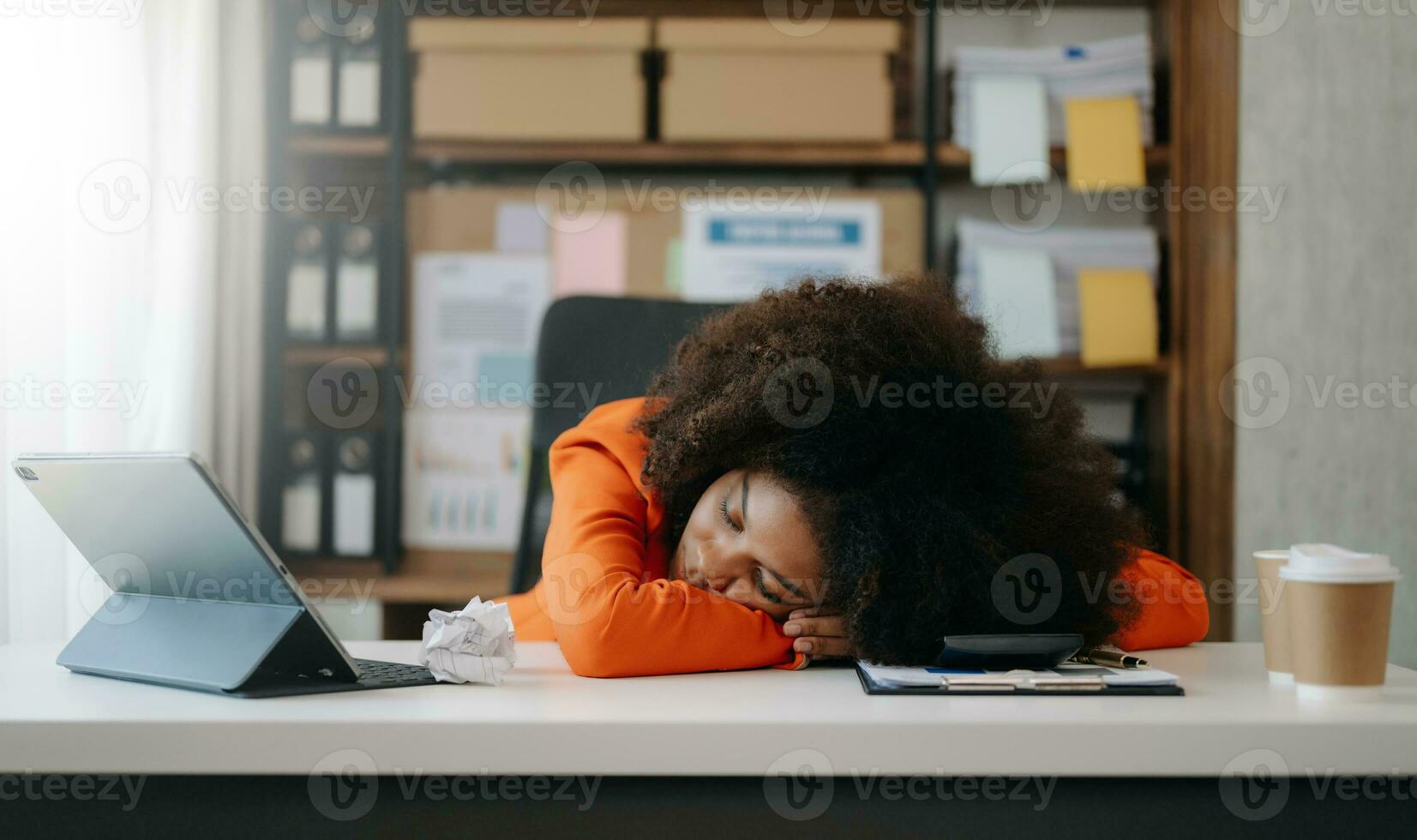 African business woman is stressed, bored, and overthinking from working on a tablet at the office. photo
