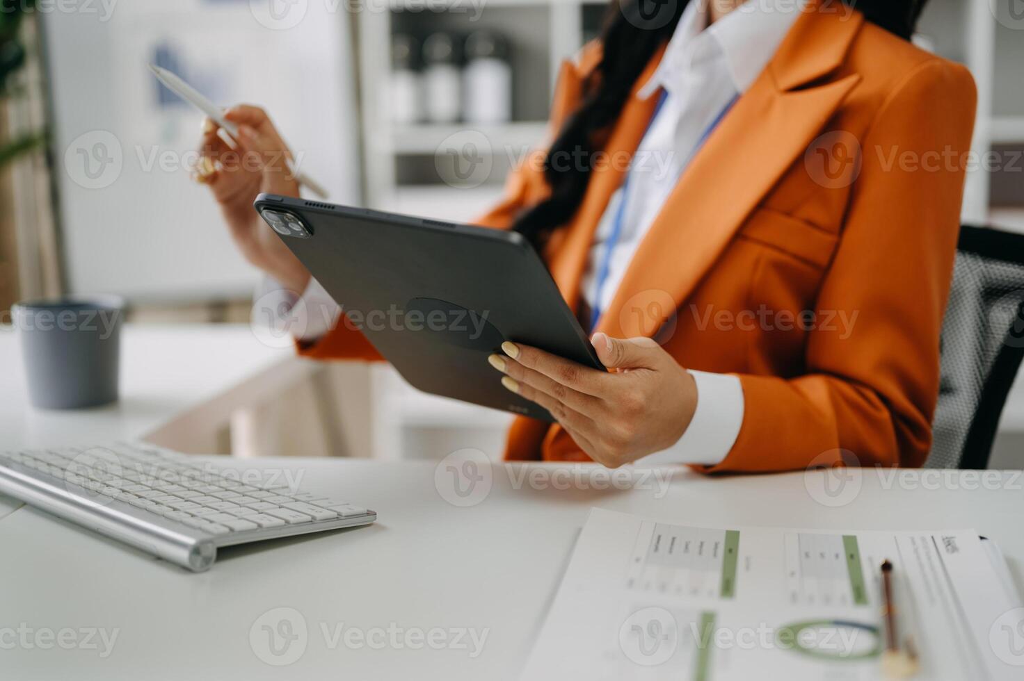 business documents on office table with smart phone and digital tablet and graph financial and woman working at modern office photo
