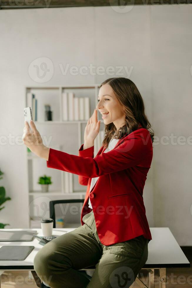 concepto de mujer trabajadora una gerente que asiste a una videoconferencia y sostiene una tableta, un teléfono inteligente y una taza de café en la oficina foto