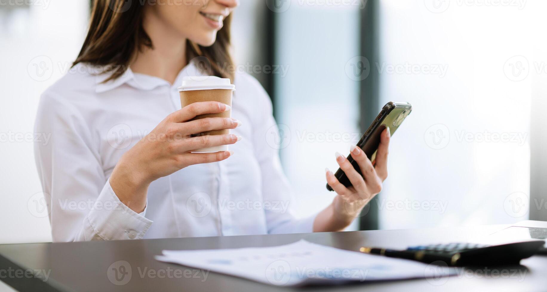 business documents on office table with smart phone and digital tablet and graph financial and woman working at modern office photo