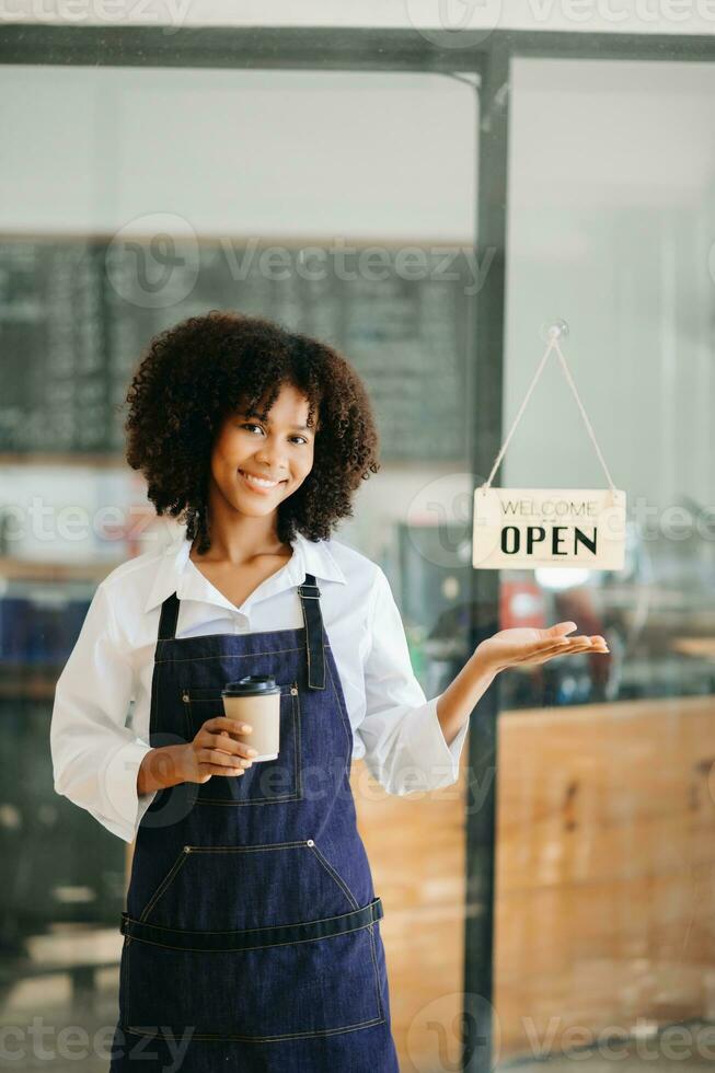 Startup successful small business owner sme African woman stand with tablet  in cafe restaurant. woman barista cafe owner. photo