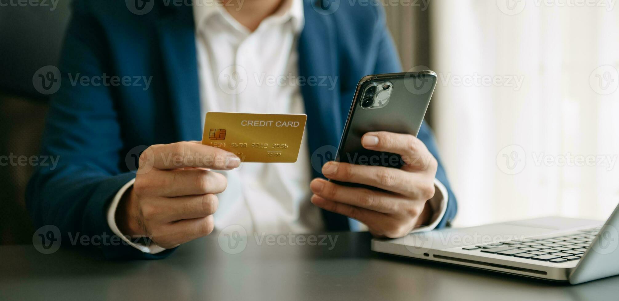 Man using smart phone for mobile payments online shopping,omni channel,sitting on table,virtual icons graphics interface screen photo