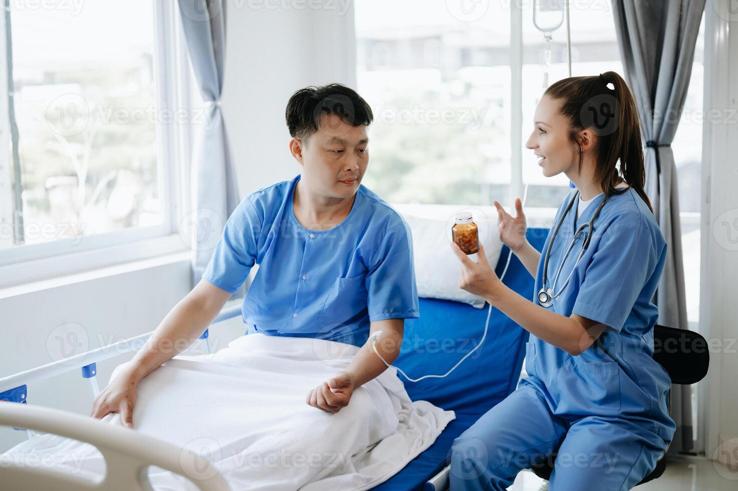 Doctor in white suit take notes while discussing and Asian elderly, man patient who lying on bed with receiving saline solution in hospital or clinic. photo