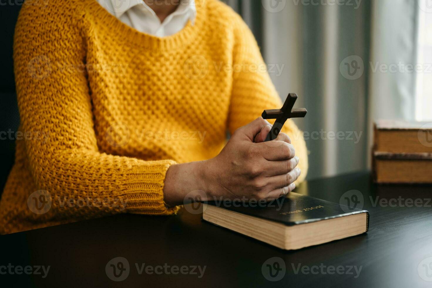 Hands together in prayer to God along with the bible In the Christian concept and religion, woman pray in the Bible on the wooden table photo