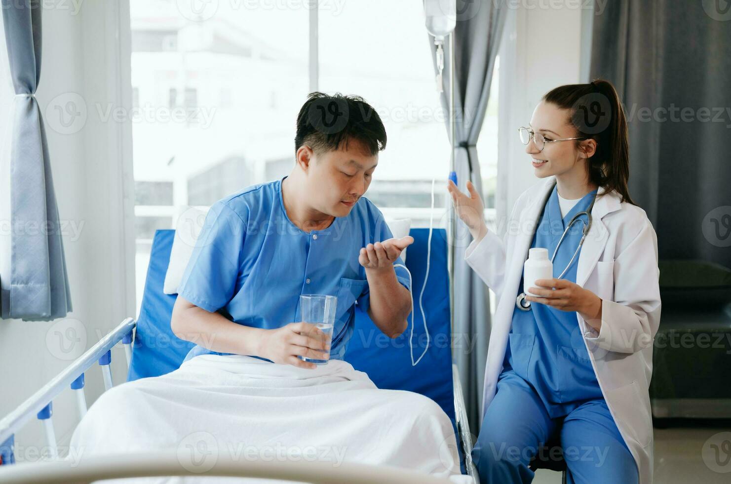 médico en blanco traje tomar notas mientras que se discute y asiático anciano, hombre paciente quien acostado en cama con recepción salina solución en hospital o clínica. foto