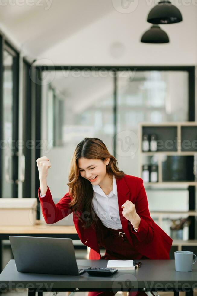 Asian business woman are delighted and happy with the work they do on their tablet, laptop and taking notes at the office. photo