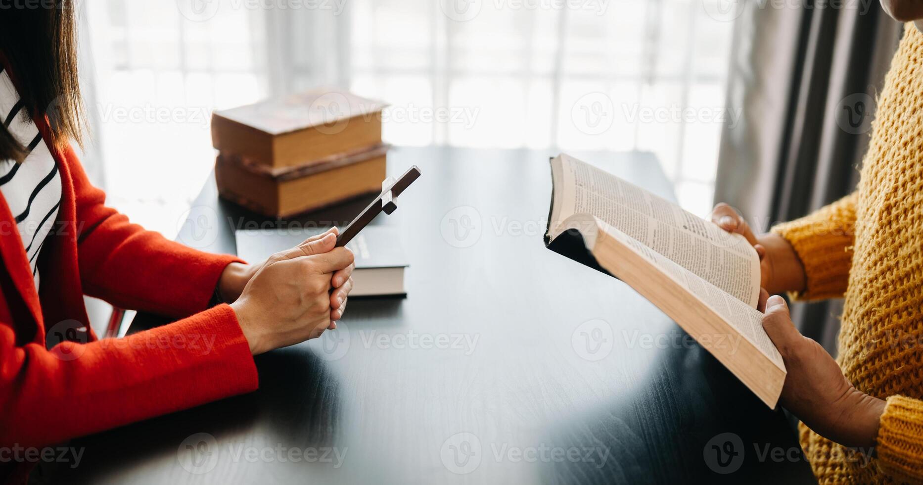 Two people reading and study bible in home and pray together.Studying the Word Of God With Friends. photo