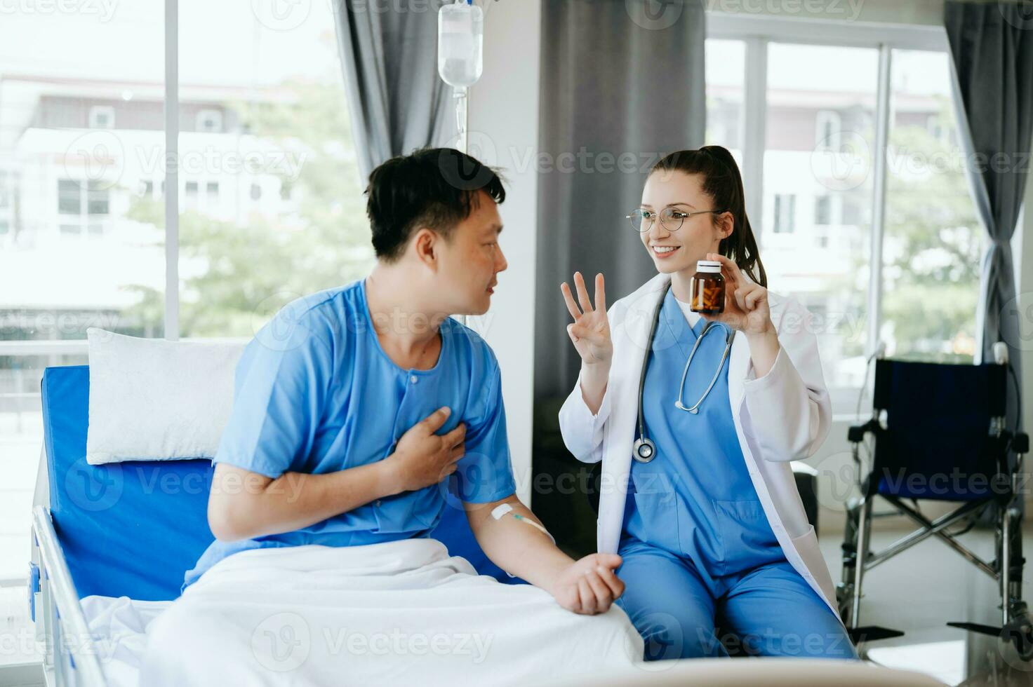 médico en blanco traje tomar notas mientras que se discute y asiático anciano, hombre paciente quien acostado en cama con recepción salina solución en hospital o clínica. foto
