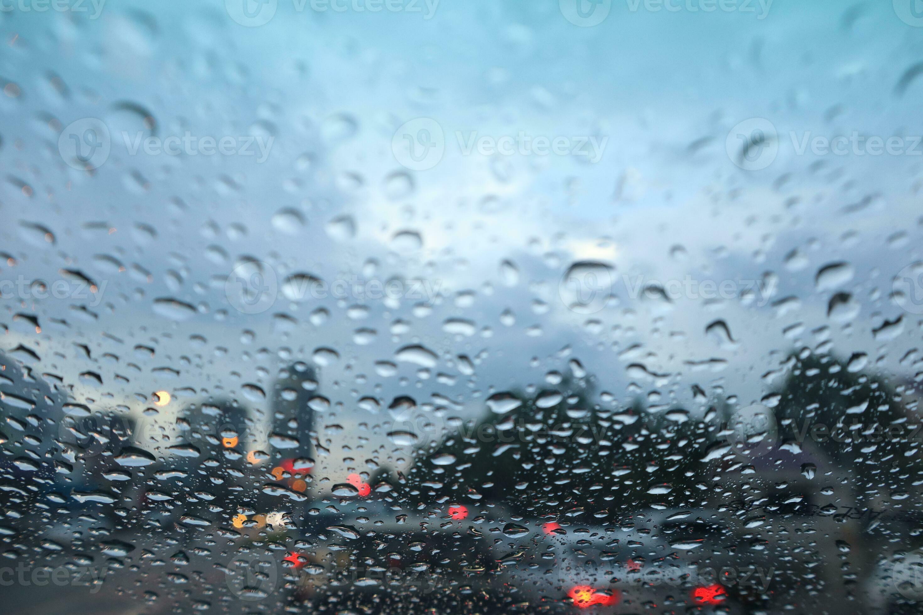 rain drop on car window with city view in the background Blur