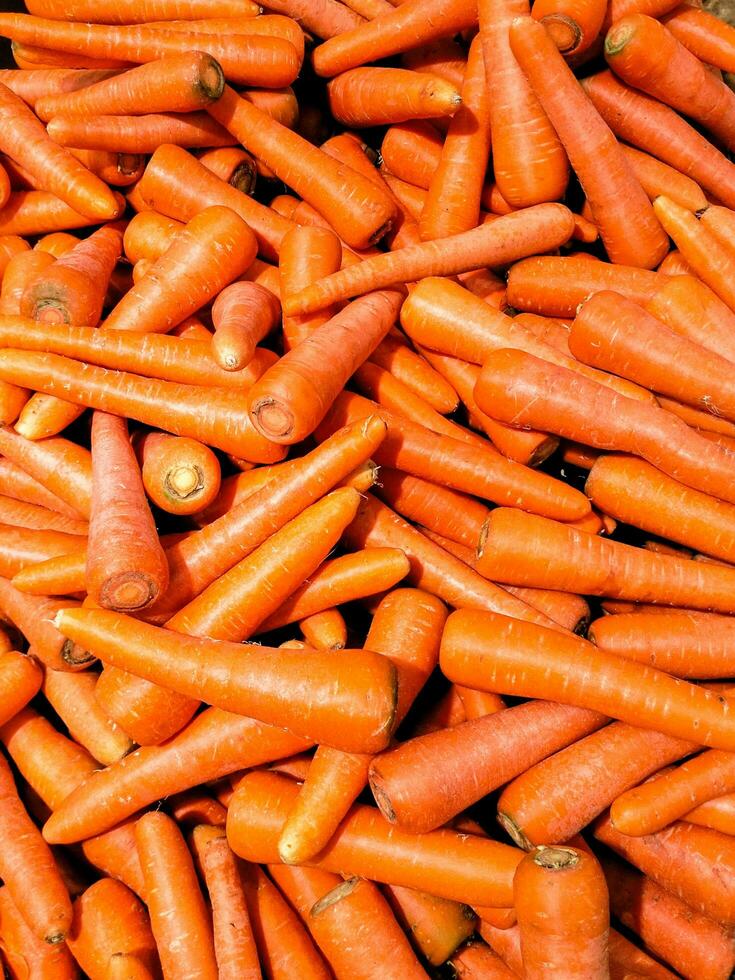 Selective view of fresh ripe orange carrots placed on stall in local supermarket photo