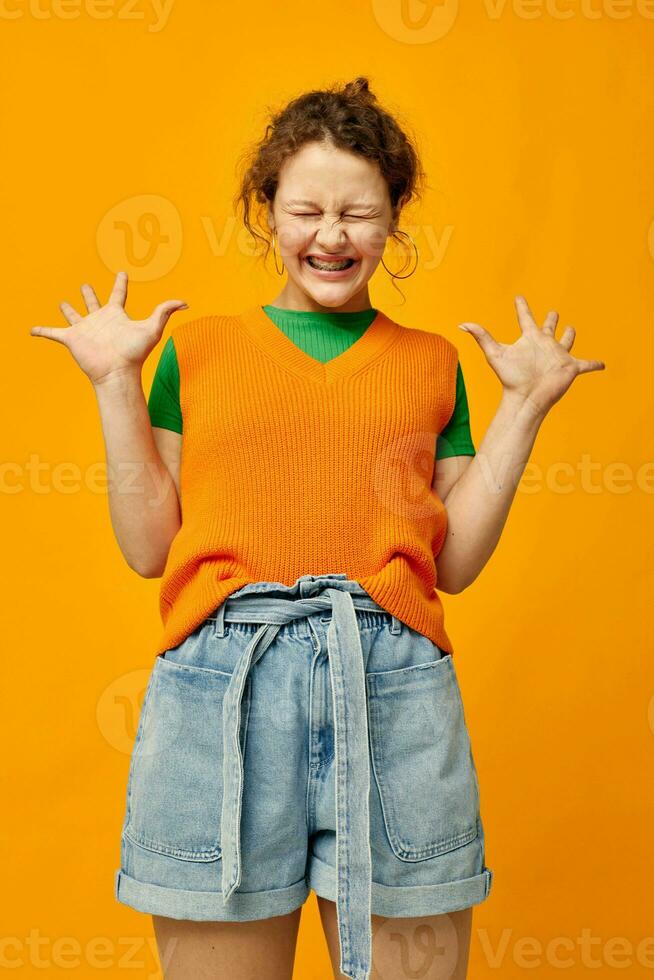 portrait of a young girl in an orange sweater denim shorts photo