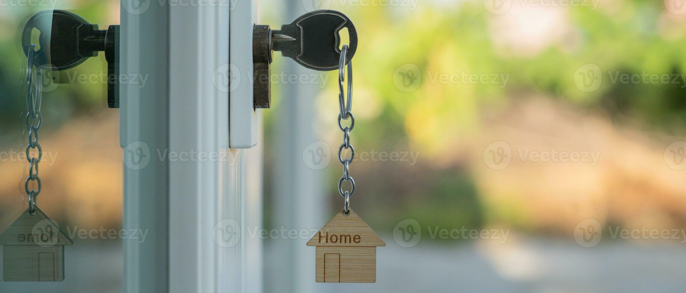 Landlord key for unlocking house is plugged into the door. Second hand house for rent and sale. keychain is blowing in the wind. mortgage for new home, buy, sell, renovate, investment, owner, estate photo