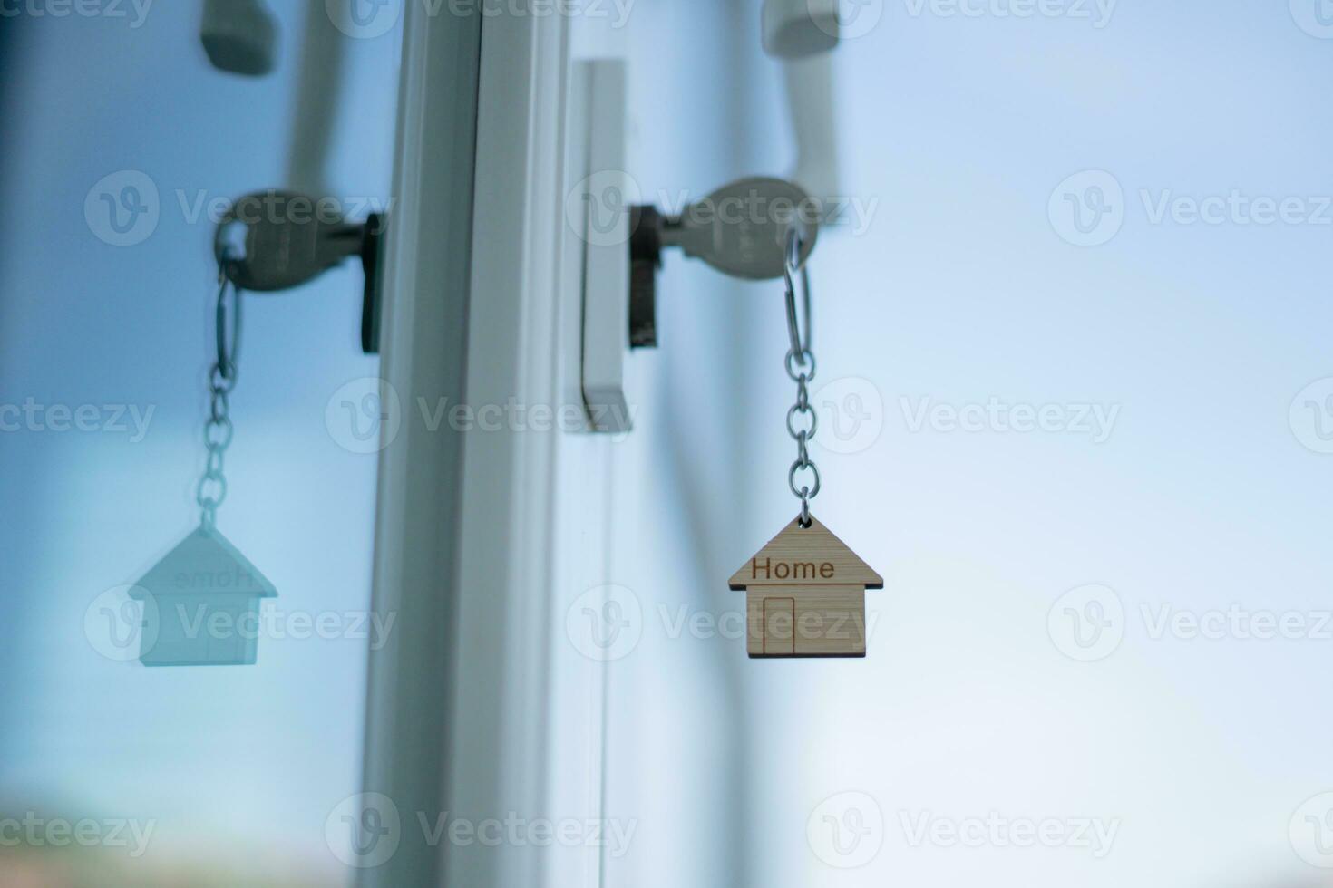 Landlord key for unlocking house is plugged into the door. Second hand house for rent and sale. keychain is blowing in the wind. mortgage for new home, buy, sell, renovate, investment, owner, estate photo