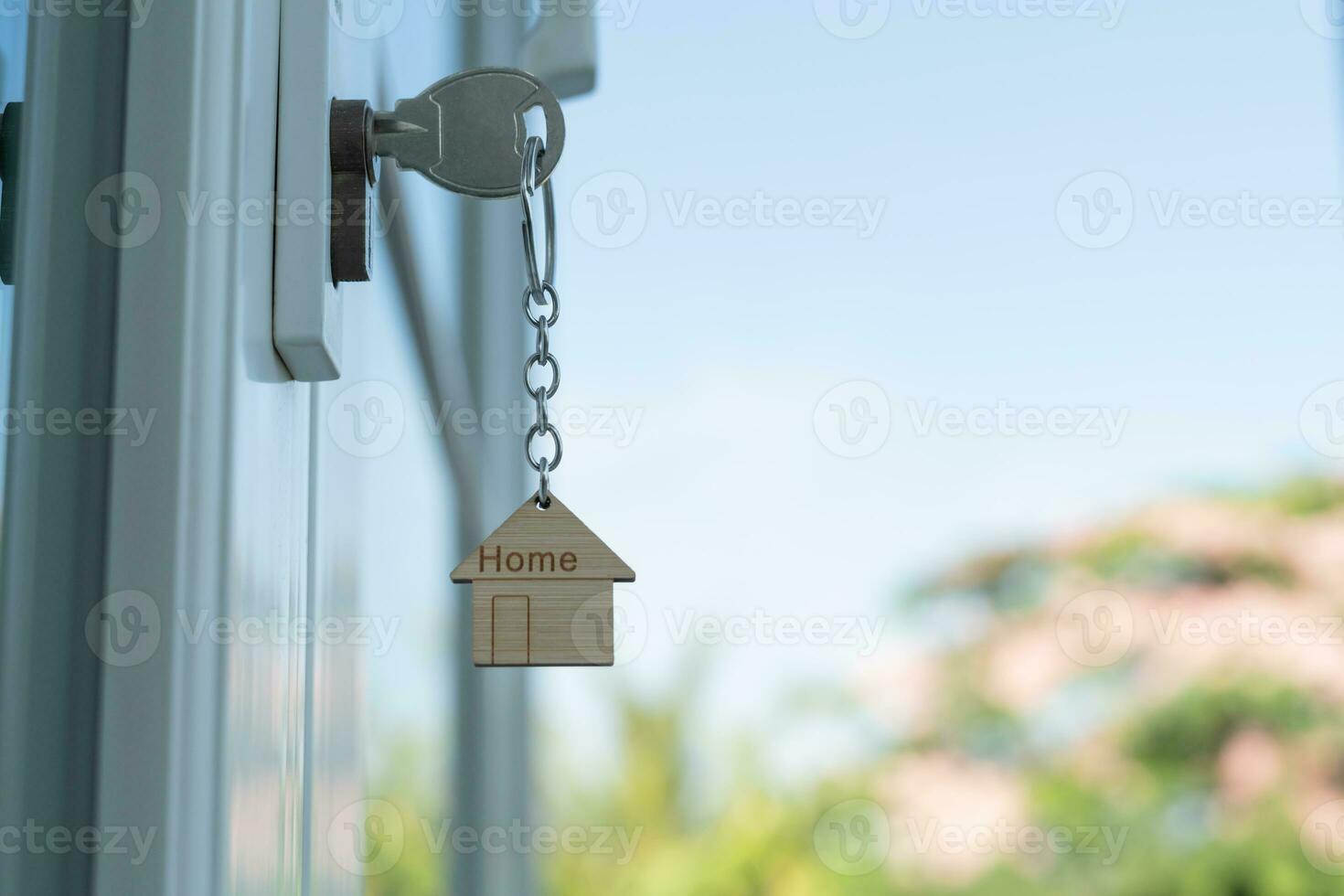 Landlord key for unlocking house is plugged into the door. Second hand house for rent and sale. keychain is blowing in the wind. mortgage for new home, buy, sell, renovate, investment, owner, estate photo