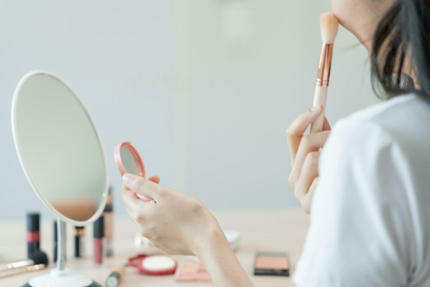 Beautiful Asian woman sit in front of a mirror. face of a healthy woman applying makeup. Advertisement for skin care, anti-wrinkle, baby face, whitening, moisturizer, tighten pores serum photo