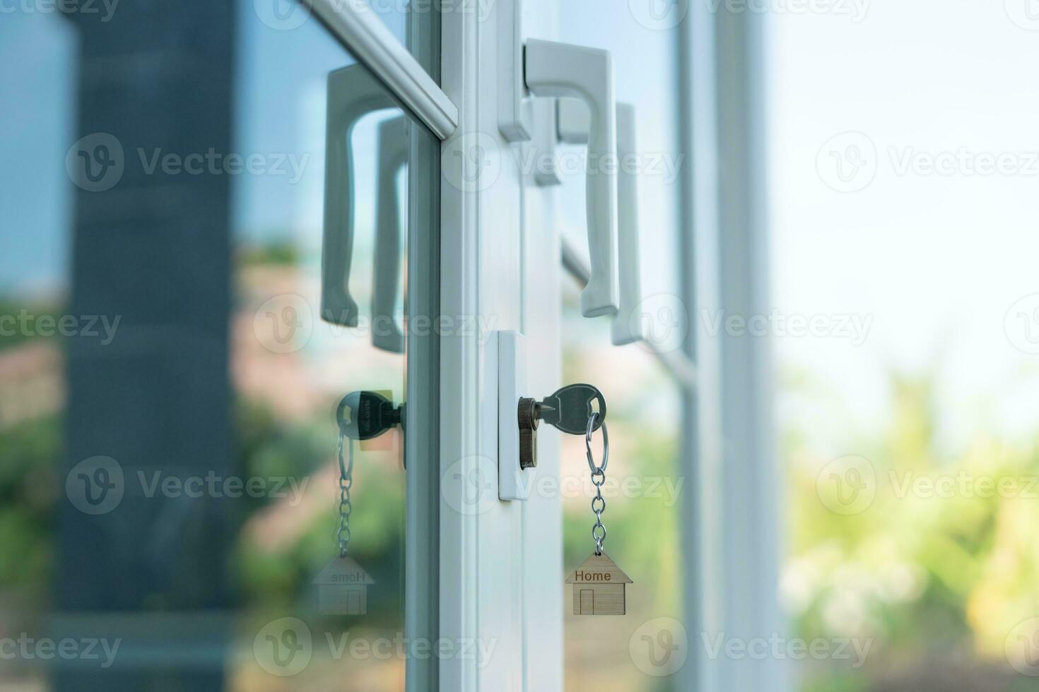 Landlord key for unlocking house is plugged into the door. Second hand house for rent and sale. keychain is blowing in the wind. mortgage for new home, buy, sell, renovate, investment, owner, estate photo
