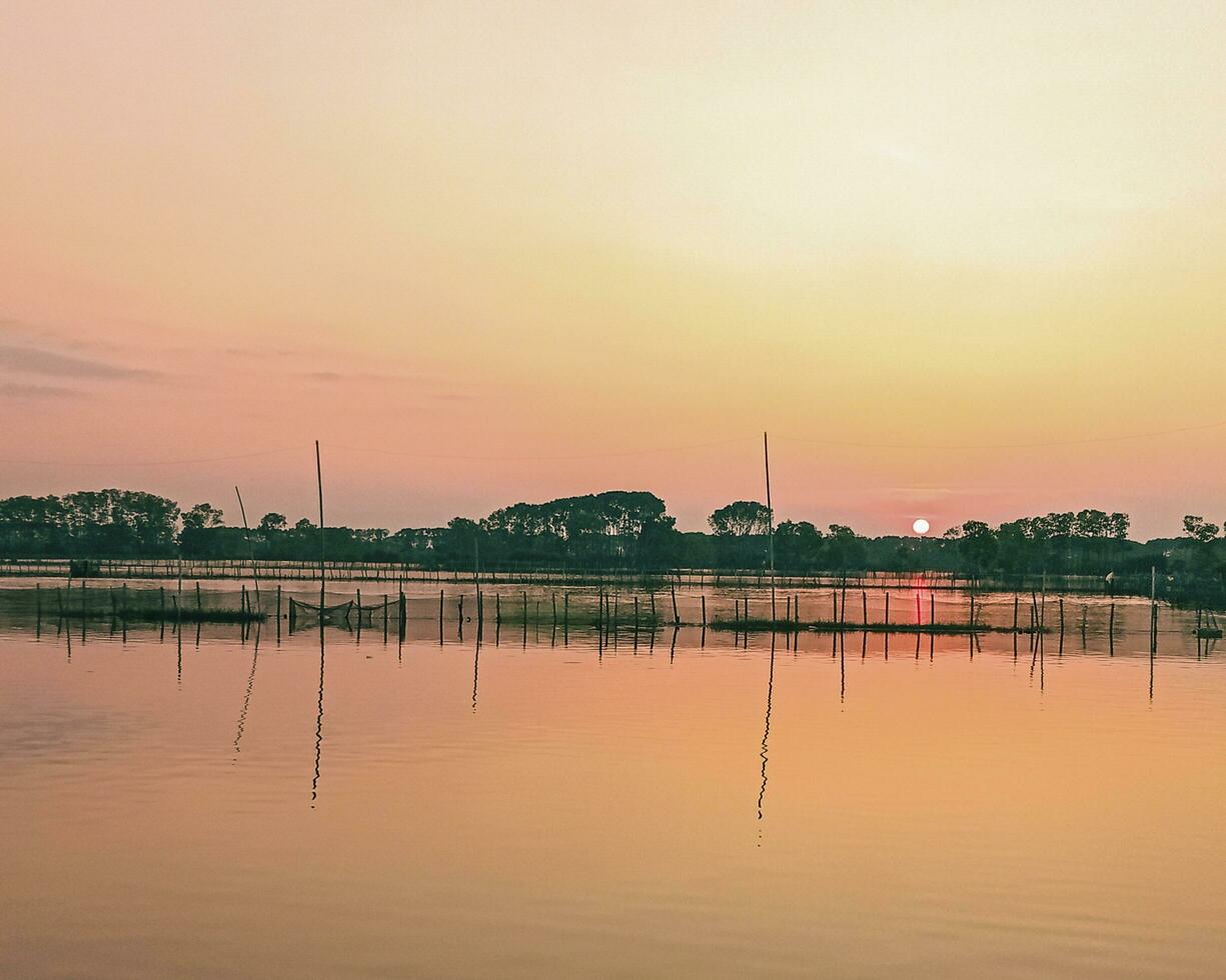 puesta de sol terminado el lago por el mar foto