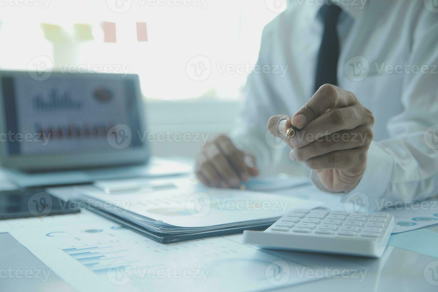 Close up businessman hand using calculator and working with laptop calculate about finance accounting at coffeeshop outdor.finance accounting concept photo