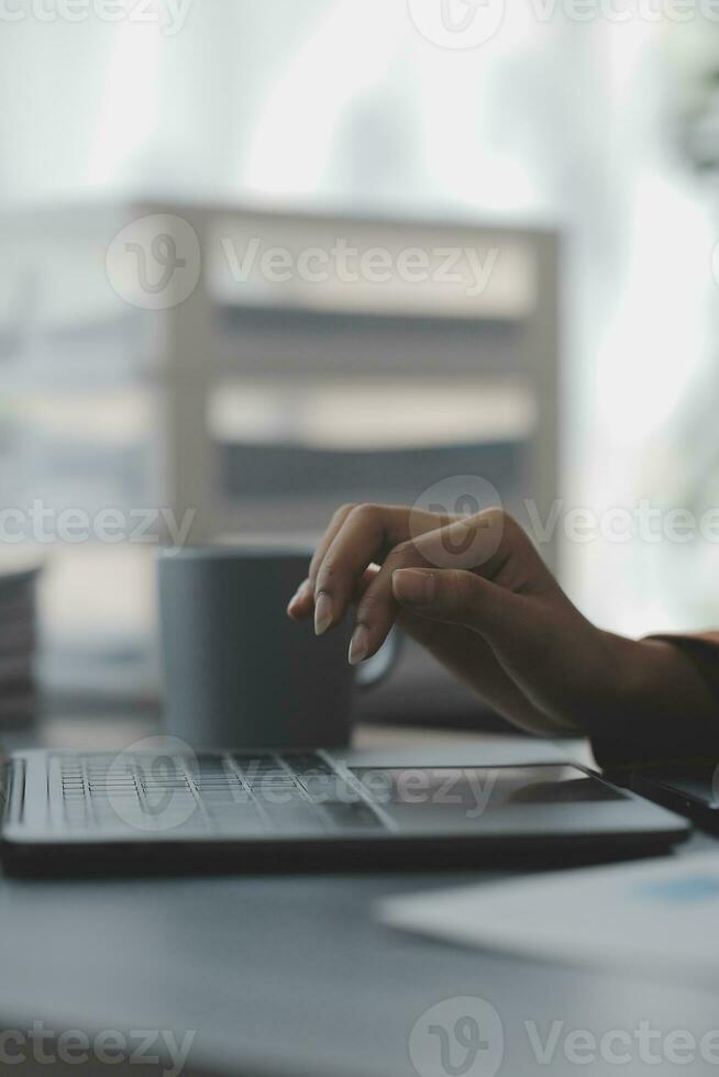 Asian Business woman using calculator and laptop for doing math finance on an office desk, tax, report, accounting, statistics, and analytical research concept photo