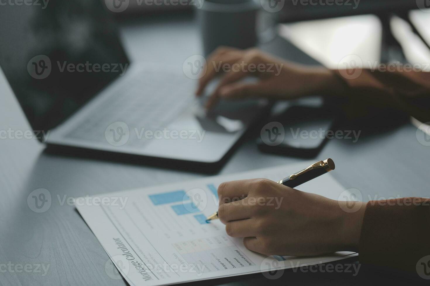 Asian Business woman using calculator and laptop for doing math finance on an office desk, tax, report, accounting, statistics, and analytical research concept photo