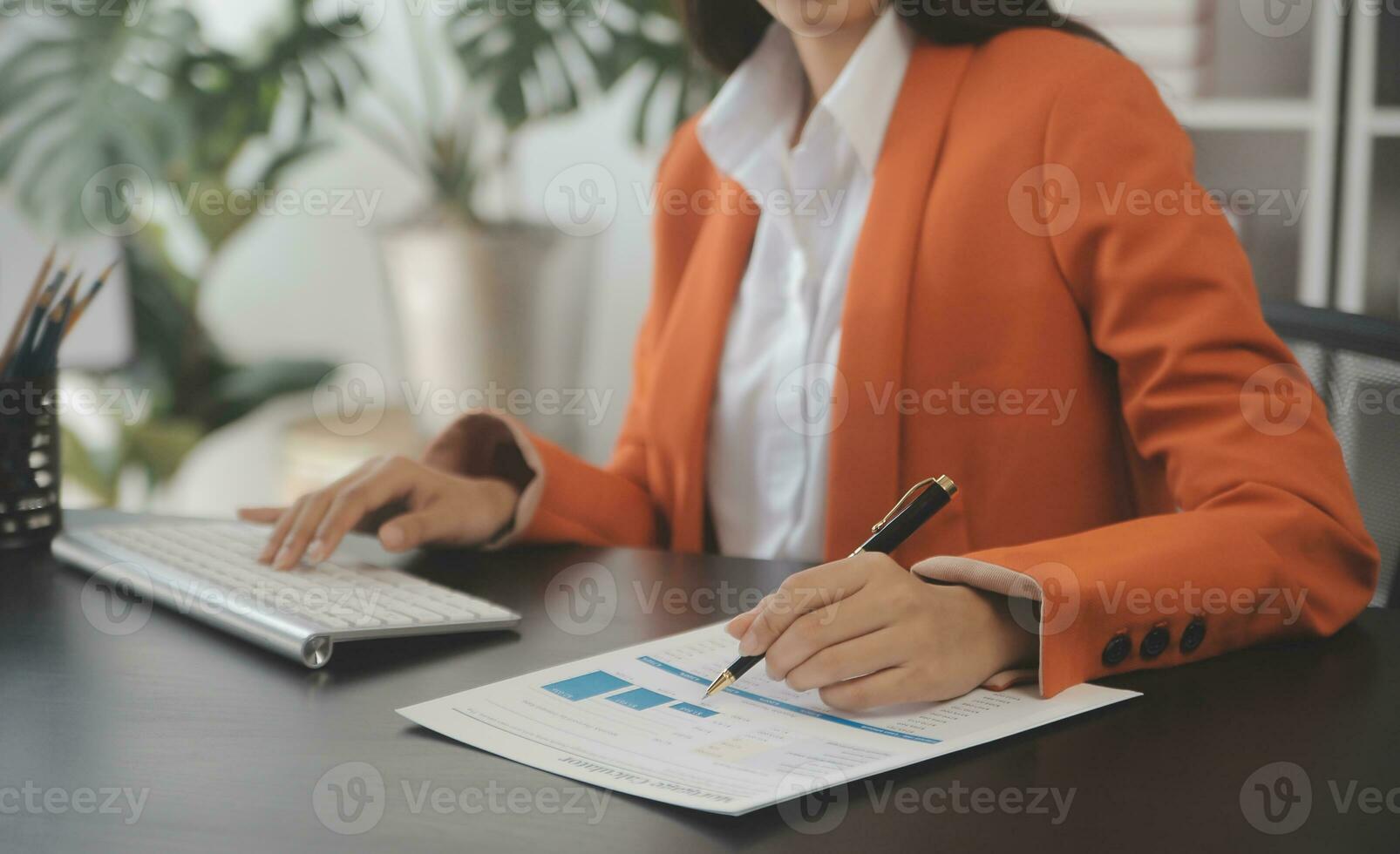 Asian Business woman using calculator and laptop for doing math finance on an office desk, tax, report, accounting, statistics, and analytical research concept photo