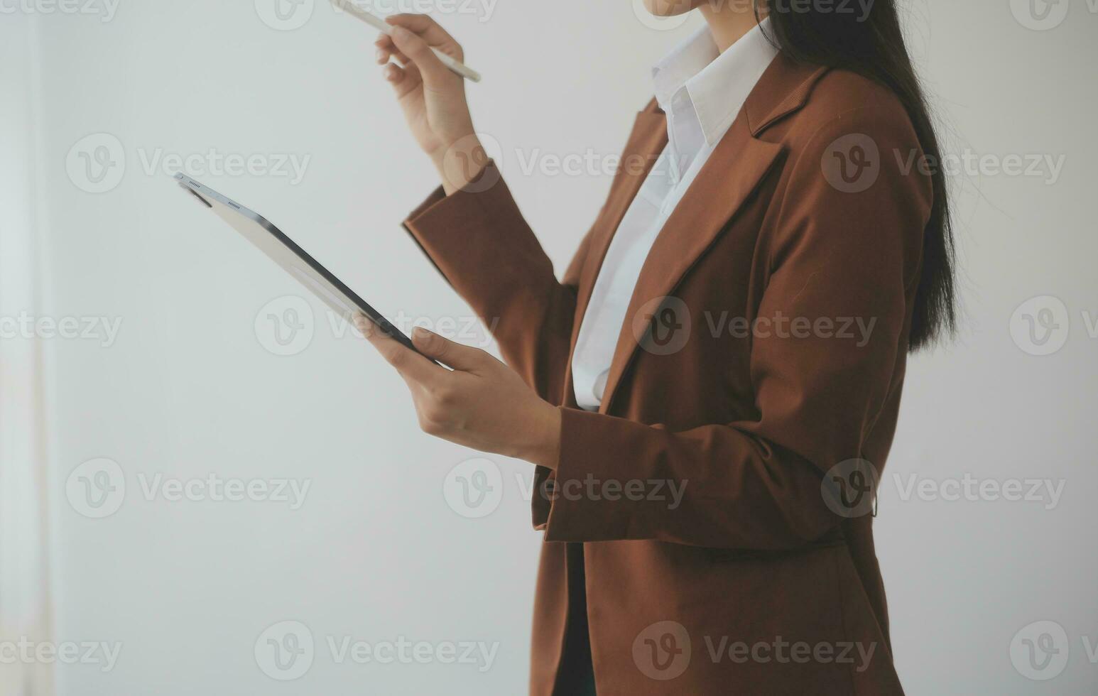 Asian Business woman using calculator and laptop for doing math finance on an office desk, tax, report, accounting, statistics, and analytical research concept photo