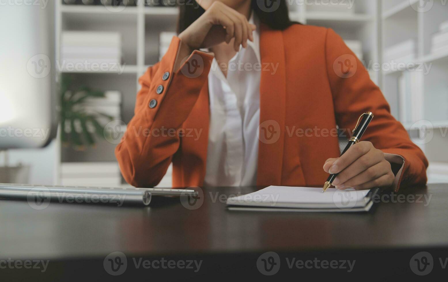 Asian Business woman using calculator and laptop for doing math finance on an office desk, tax, report, accounting, statistics, and analytical research concept photo