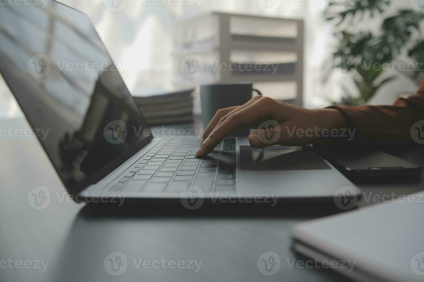 Asian Business woman using calculator and laptop for doing math finance on an office desk, tax, report, accounting, statistics, and analytical research concept photo