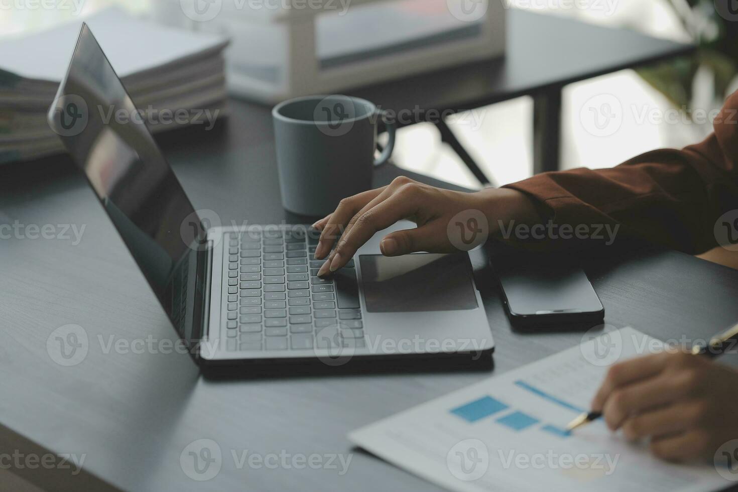 Asian Business woman using calculator and laptop for doing math finance on an office desk, tax, report, accounting, statistics, and analytical research concept photo