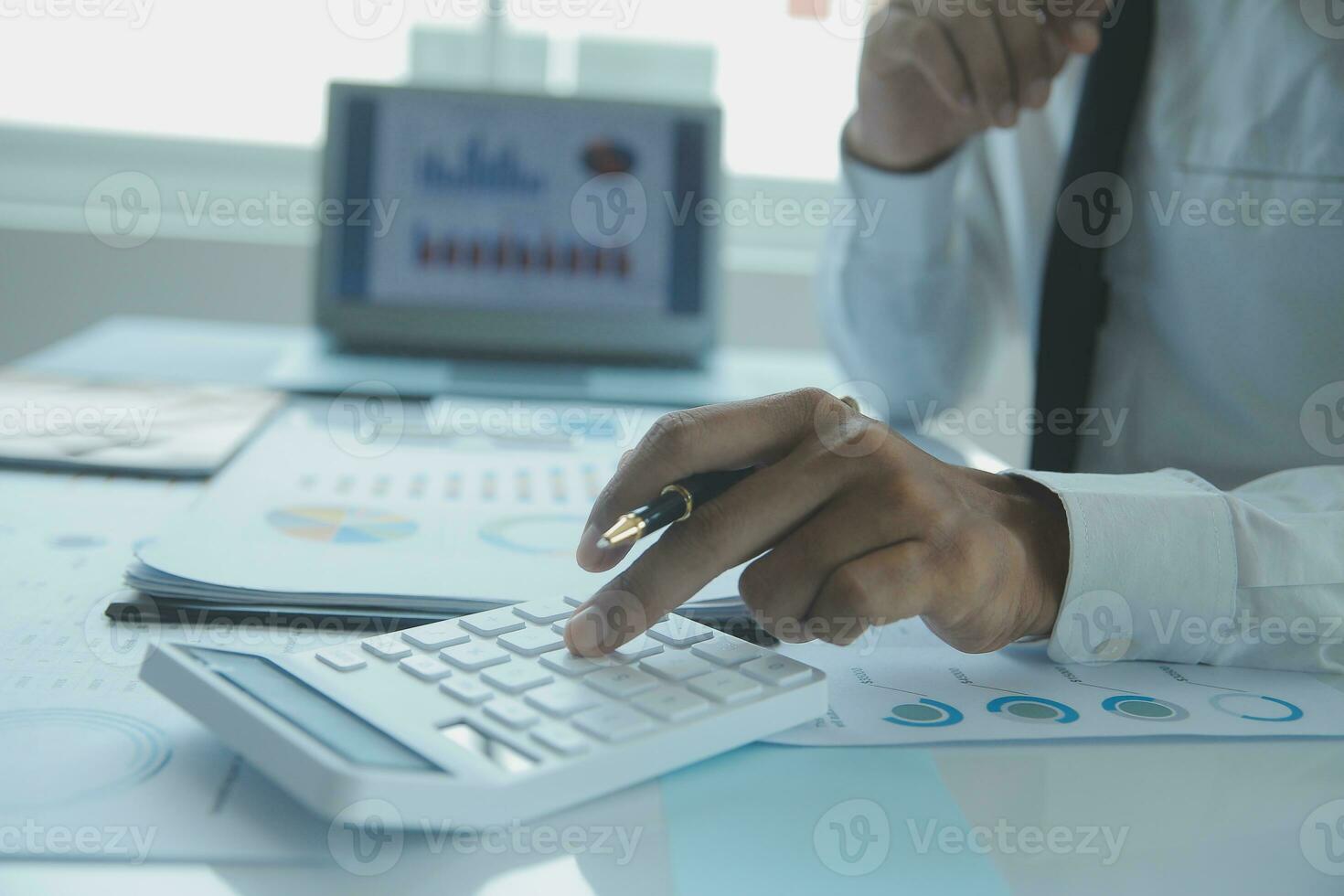 Close up businessman hand using calculator and working with laptop calculate about finance accounting at coffeeshop outdor.finance accounting concept photo