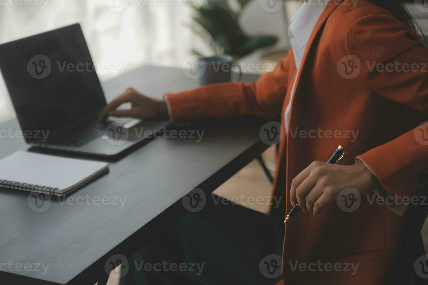 Asian Business woman using calculator and laptop for doing math finance on an office desk, tax, report, accounting, statistics, and analytical research concept photo