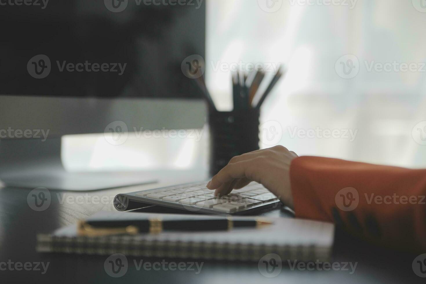 Asian Business woman using calculator and laptop for doing math finance on an office desk, tax, report, accounting, statistics, and analytical research concept photo