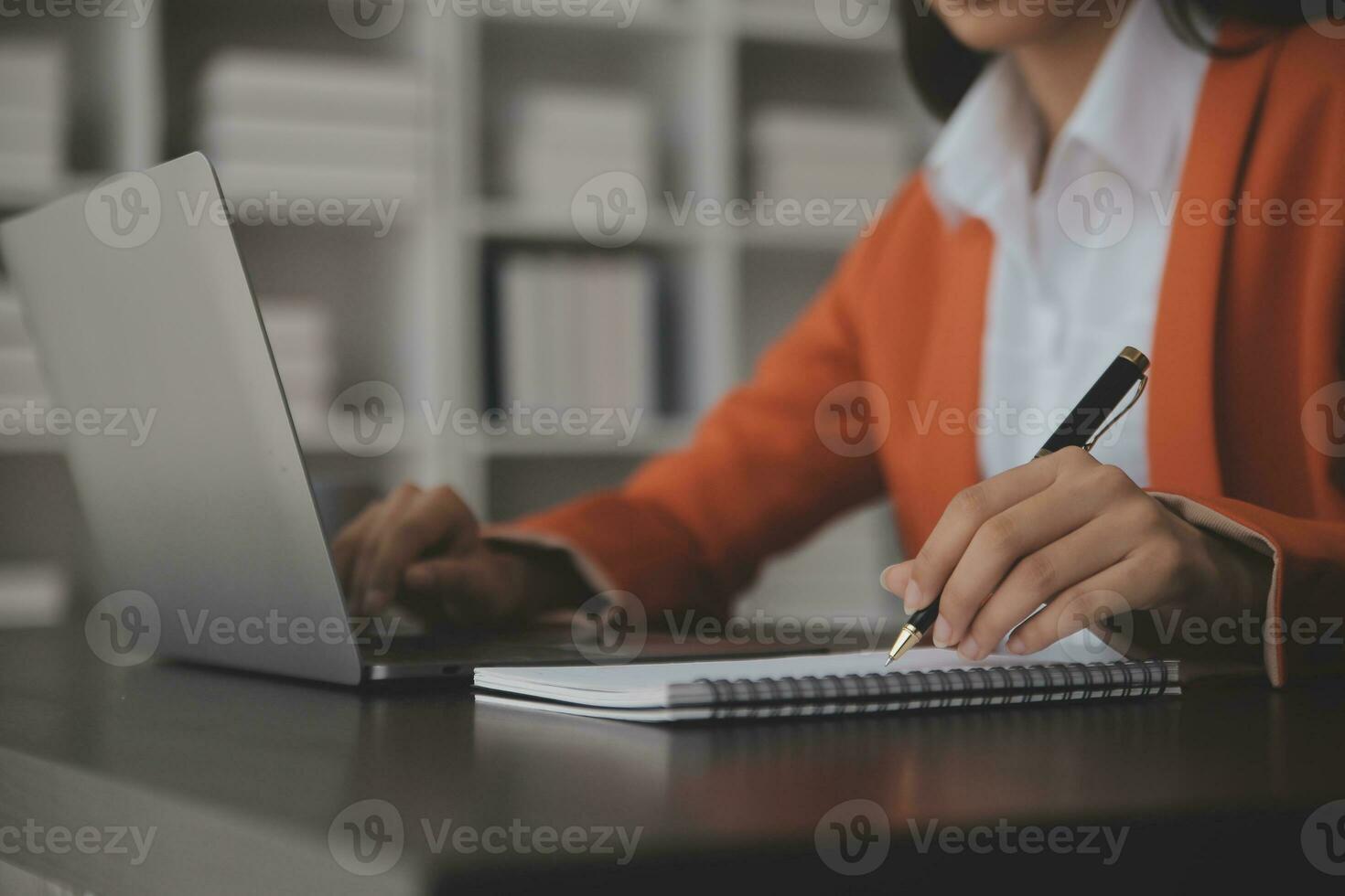 Asian Business woman using calculator and laptop for doing math finance on an office desk, tax, report, accounting, statistics, and analytical research concept photo