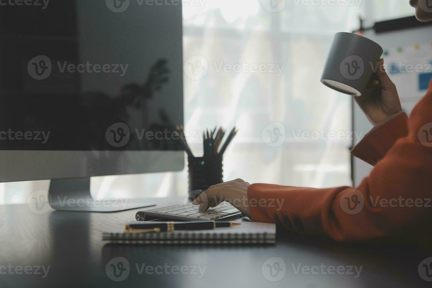 Asian Business woman using calculator and laptop for doing math finance on an office desk, tax, report, accounting, statistics, and analytical research concept photo
