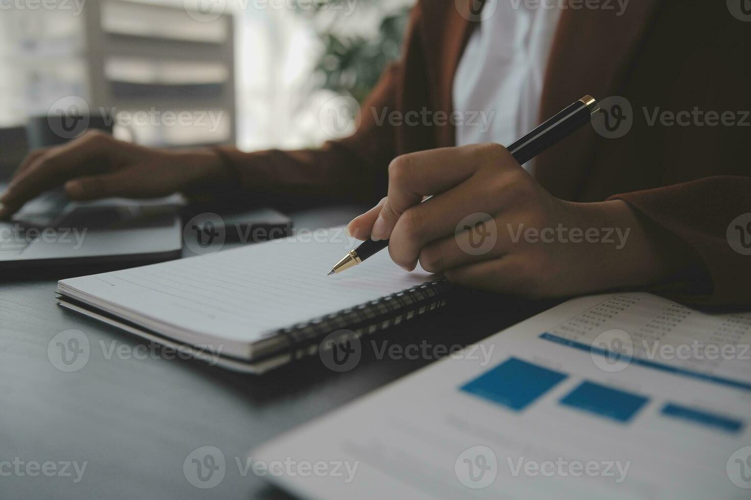Asian Business woman using calculator and laptop for doing math finance on an office desk, tax, report, accounting, statistics, and analytical research concept photo