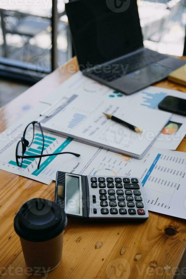 Close up of accountant working and analyzing financial reports project accounting with chart graph and calculator in modern office  finance and business concept. photo