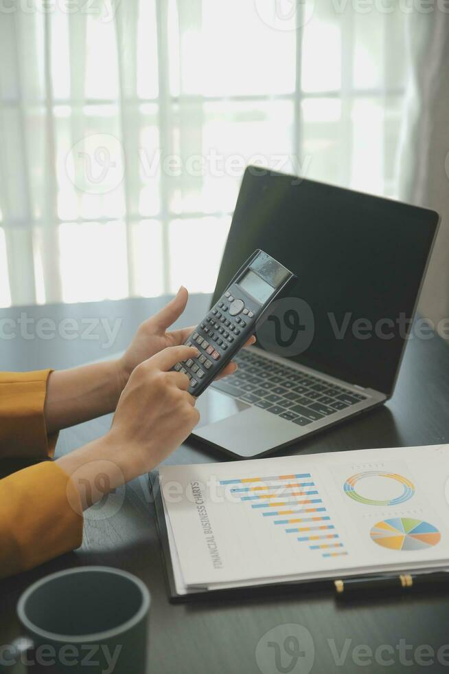 Portrait of Young Asian woman hand freelancer is working her job on computer tablet in modern office. Doing accounting analysis report real estate investment data, Financial and tax systems concept. photo