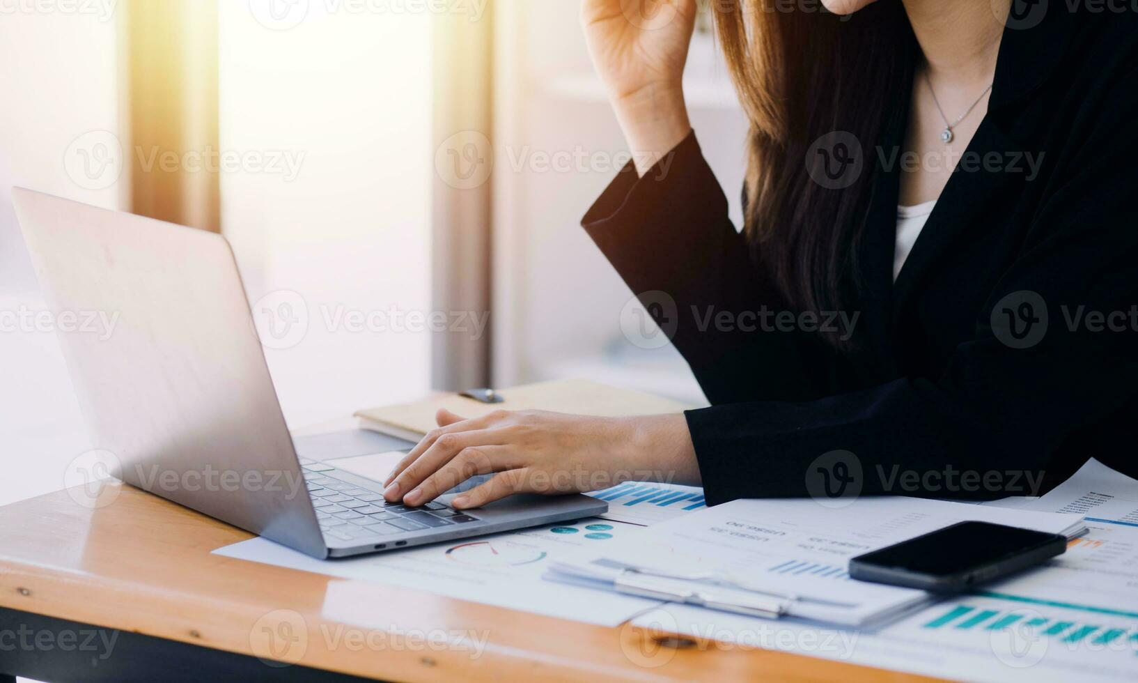 Asian Business woman using calculator and laptop for doing math finance on an office desk, tax, report, accounting, statistics, and analytical research concept photo