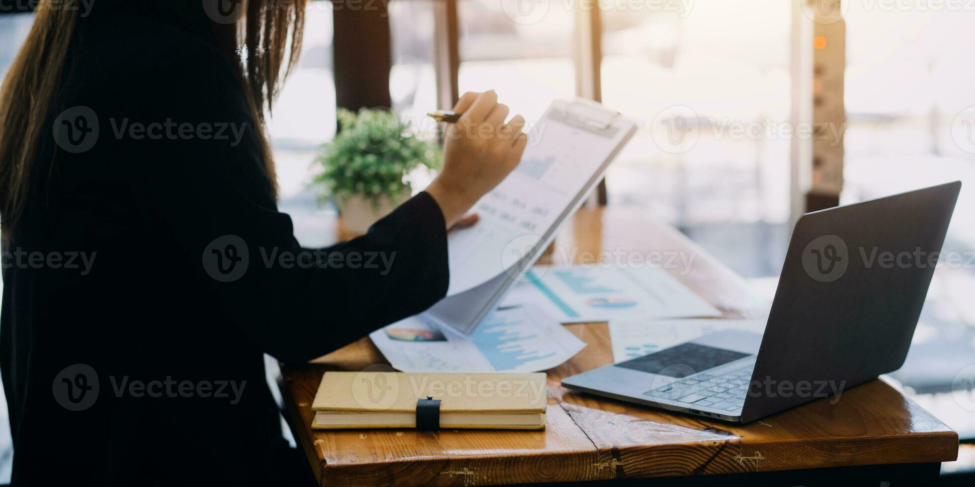 Asian Business woman using calculator and laptop for doing math finance on an office desk, tax, report, accounting, statistics, and analytical research concept photo