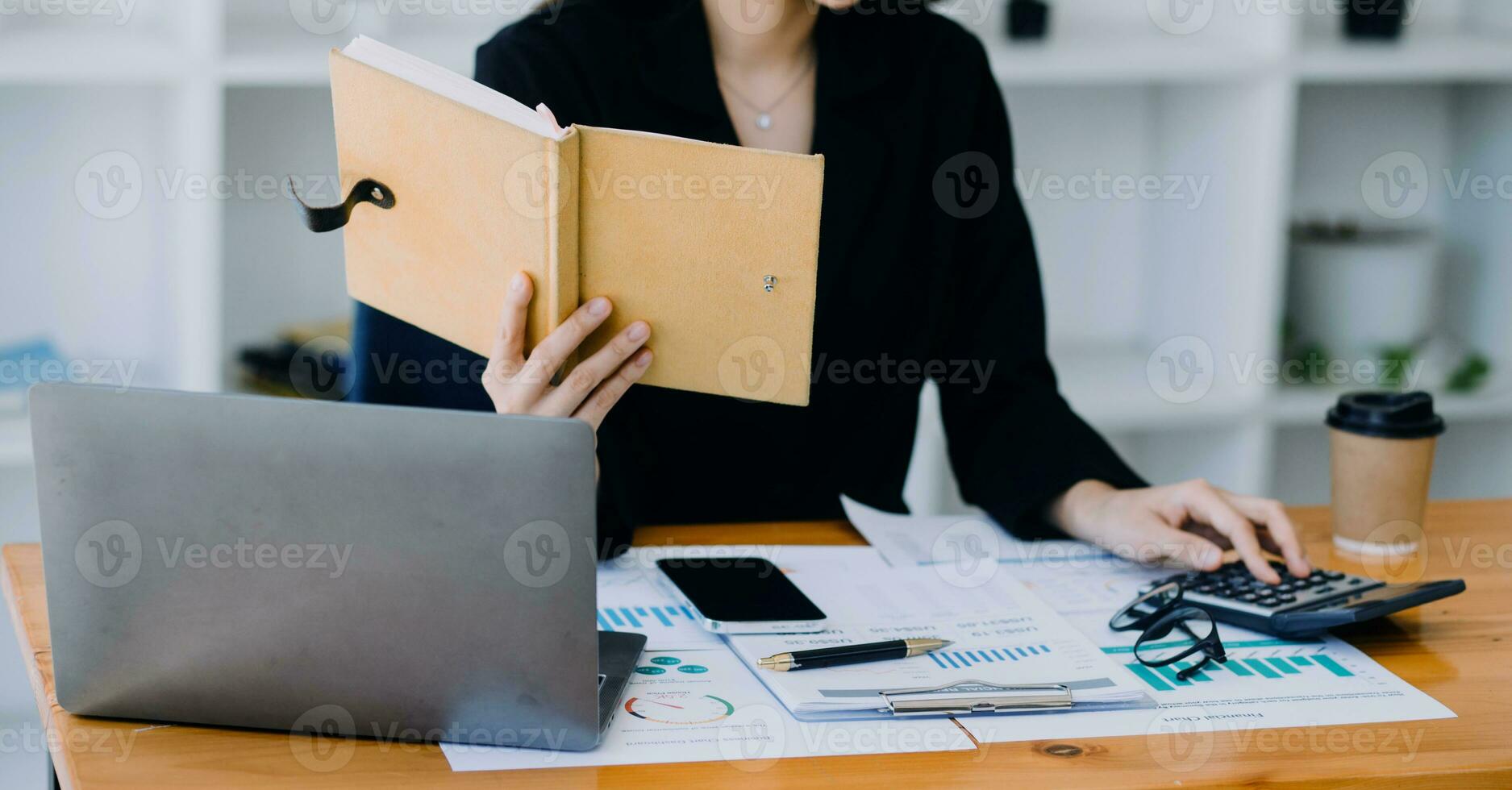 Asian Business woman using calculator and laptop for doing math finance on an office desk, tax, report, accounting, statistics, and analytical research concept photo