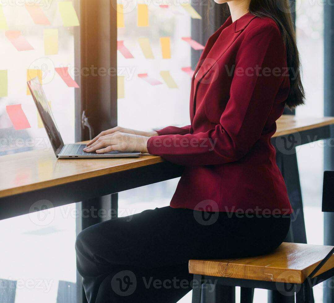 Asian Business woman using calculator and laptop for doing math finance on an office desk, tax, report, accounting, statistics, and analytical research concept photo