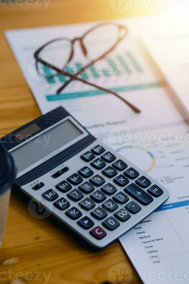 Asian Business woman using calculator and laptop for doing math finance on an office desk, tax, report, accounting, statistics, and analytical research concept photo