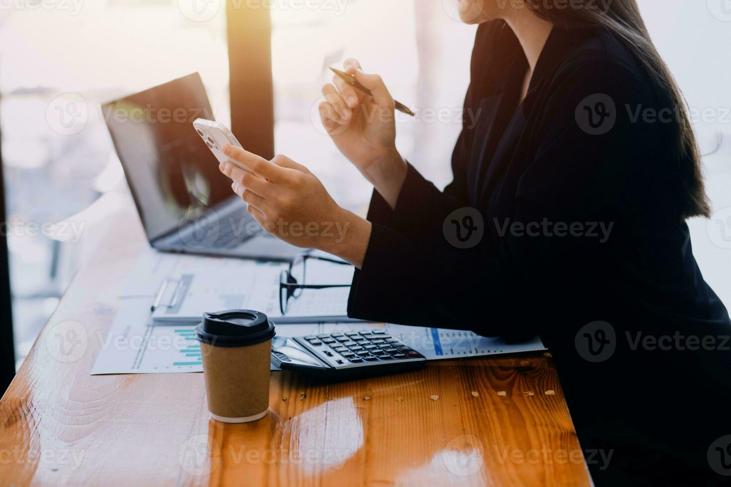 Asian Business woman using calculator and laptop for doing math finance on an office desk, tax, report, accounting, statistics, and analytical research concept photo